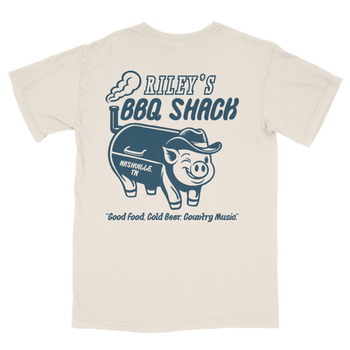 Beige t-shirt with blue graphic of a pig wearing a hat and text 'Riley's BBQ Shack' on a white background